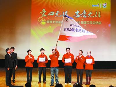 2010年,吕嘉珩作为志愿者代表,从北京市残疾人福利基金会理事长手中接过安利扶残助残服务队旗帜